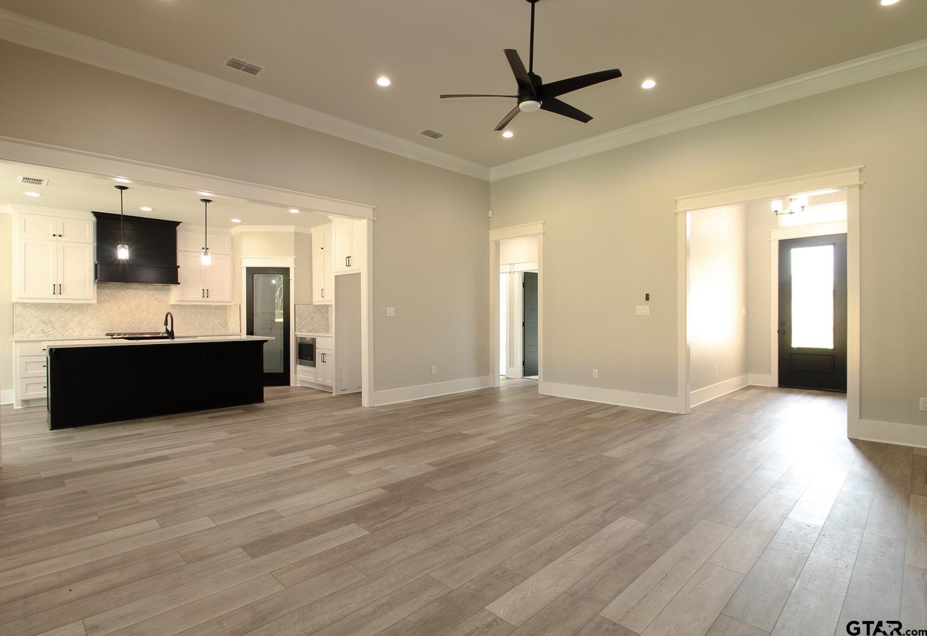1069 Stagecoach Bend Bullard, TX 75757 - Photo 8 of 44 a view of a kitchen with a sink and a flat screen tv