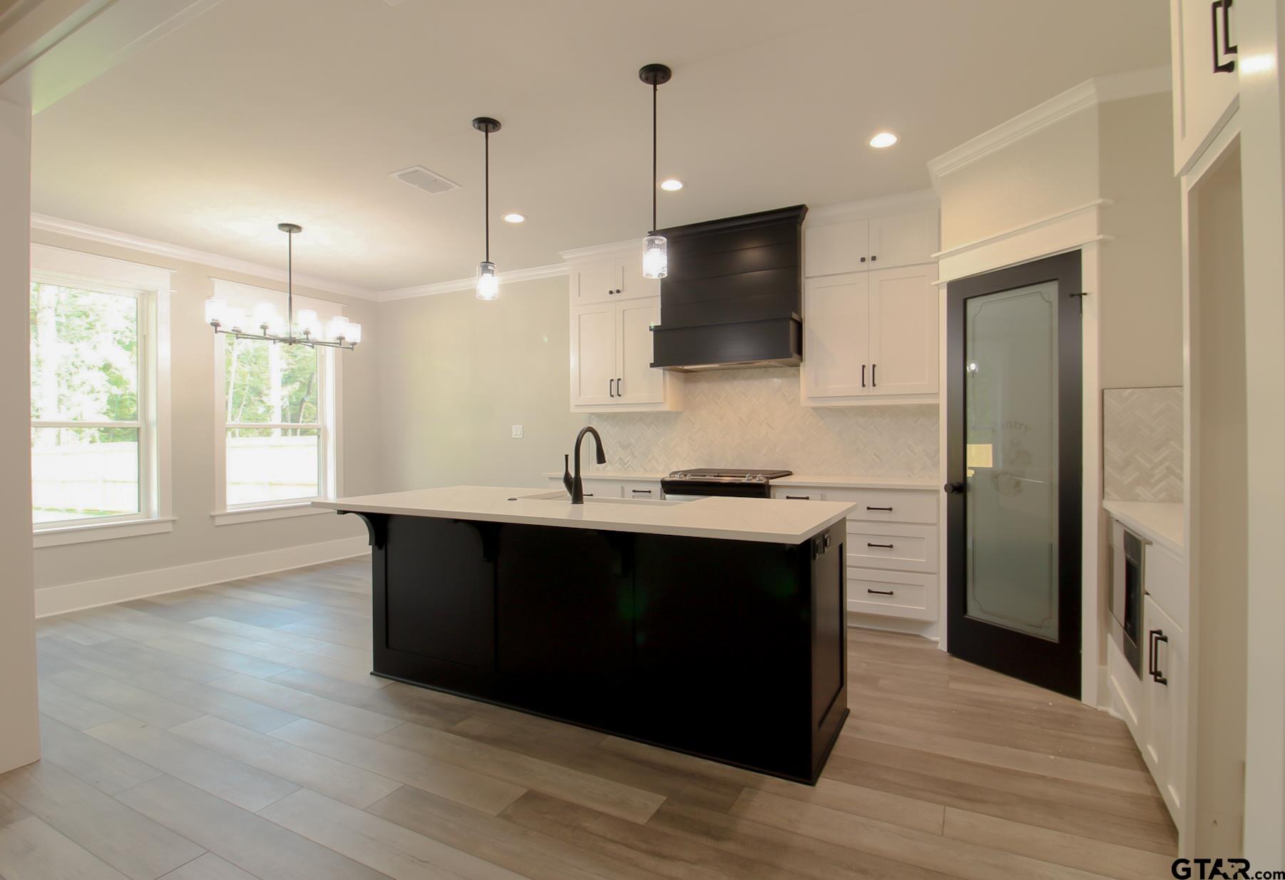 1069 Stagecoach Bend Bullard, TX 75757 - Photo 10 of 44 a kitchen with stainless steel appliances granite countertop a sink a microwave oven a refrigerator and a wooden floor