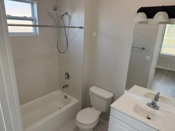 a bathroom with a toilet sink vanity tub and shower