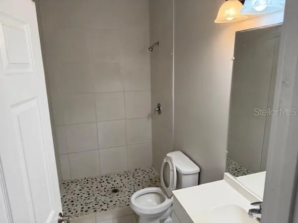 a white toilet sitting next to a bathroom sink and a mirror