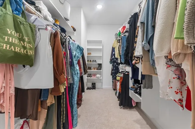 a view of walk in closet with clothes