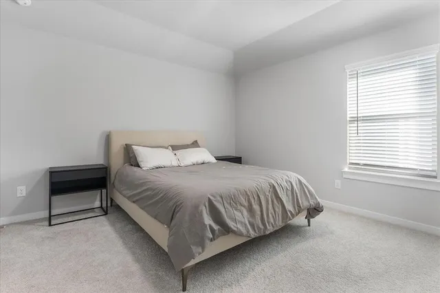 a bed sitting in a bedroom next to a window