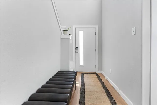 a view of a hallway with wooden floor and stairs