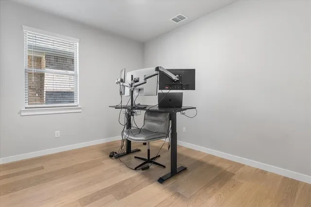 a view of a workspace with furniture and a window