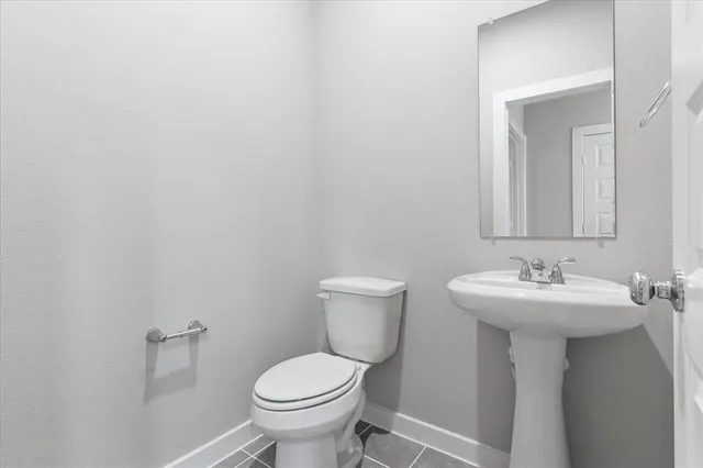 a bathroom with a sink toilet and a mirror