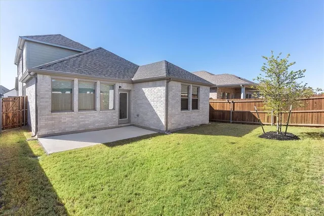a view of a yard in front of a house with a large tree