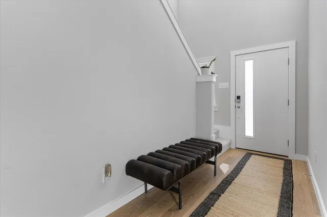 a view of a hallway with wooden floor and a cabinet