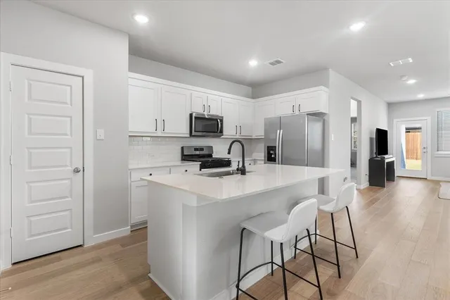 a kitchen with kitchen island a refrigerator stove and microwave