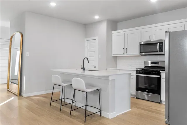 a kitchen with stainless steel appliances a sink a stove a microwave and cabinets