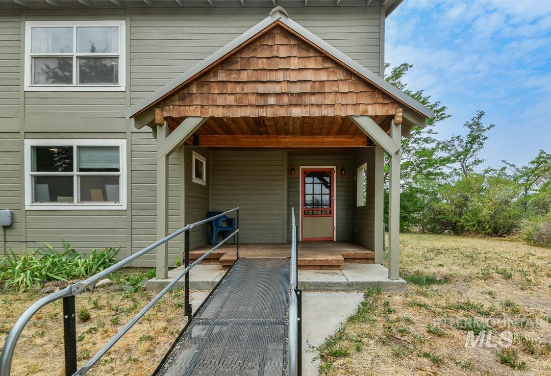 595 Cemetery Road Cambridge, ID 83610 - Photo 5 of 47 Covered entryway featuring a wood shake roof and exposed wood beams