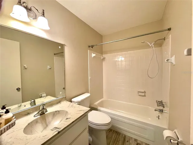 a bathroom with a granite countertop sink toilet and a shower