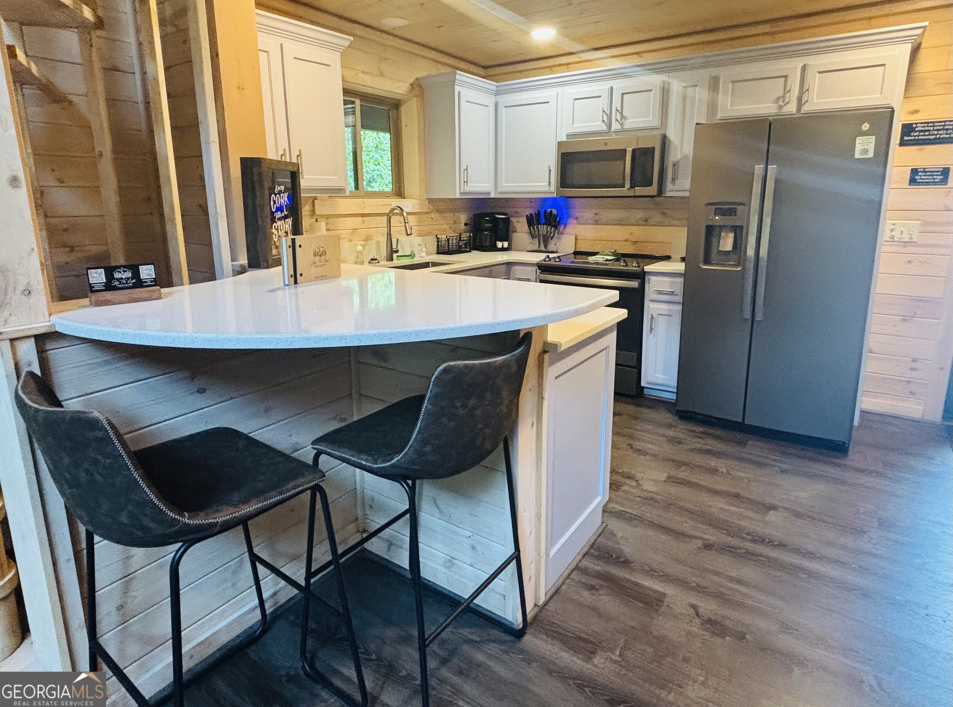 185 Walnut Ridge Drive Cleveland, GA 30528 - Photo 15 of 36 a kitchen with stainless steel appliances a dining table chairs microwave and refrigerator