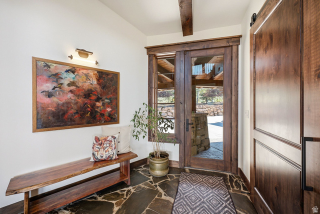 7885 North Rabbitbrush Court, Unit 13 Park City, UT 84098 - Photo 56 of 88 Entryway featuring natural stone flooring, a large wood-framed glass door, exposed wood beam ceiling, and a barn-style wood door
