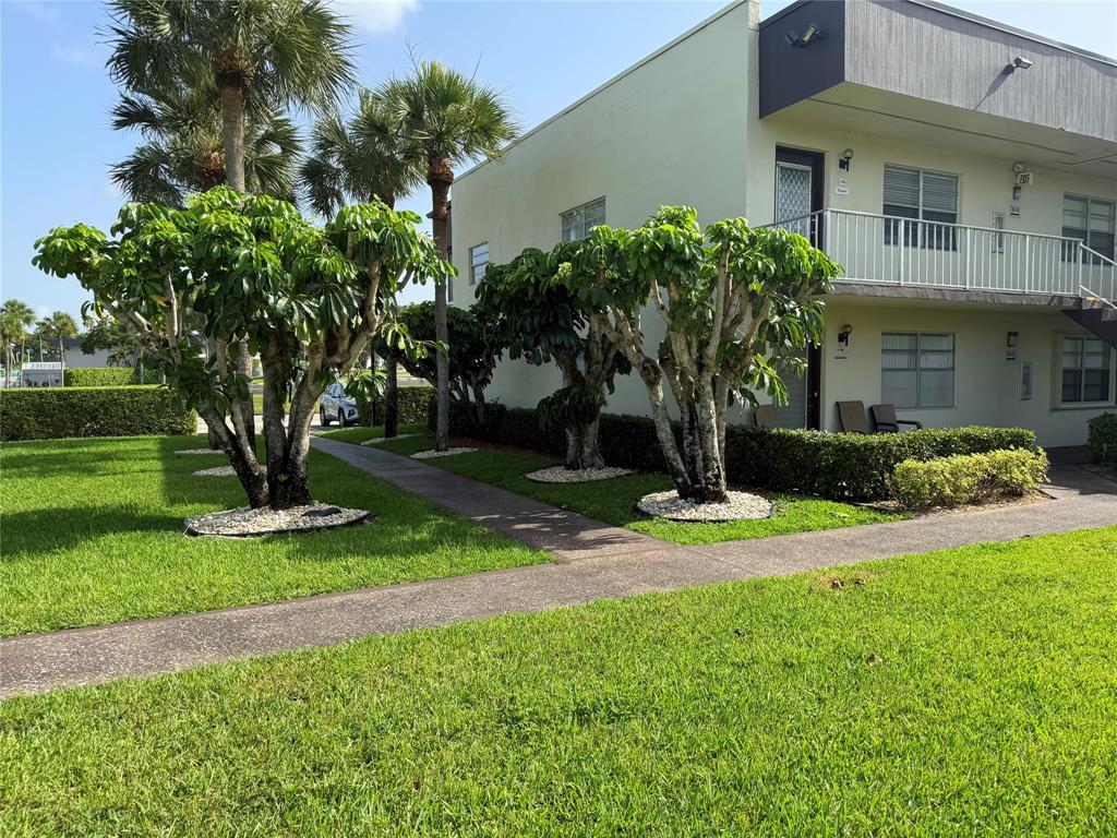 768 P Normandy, Unit 768 Delray Beach, FL 33484 - Photo 12 of 34 a front view of a house with a yard