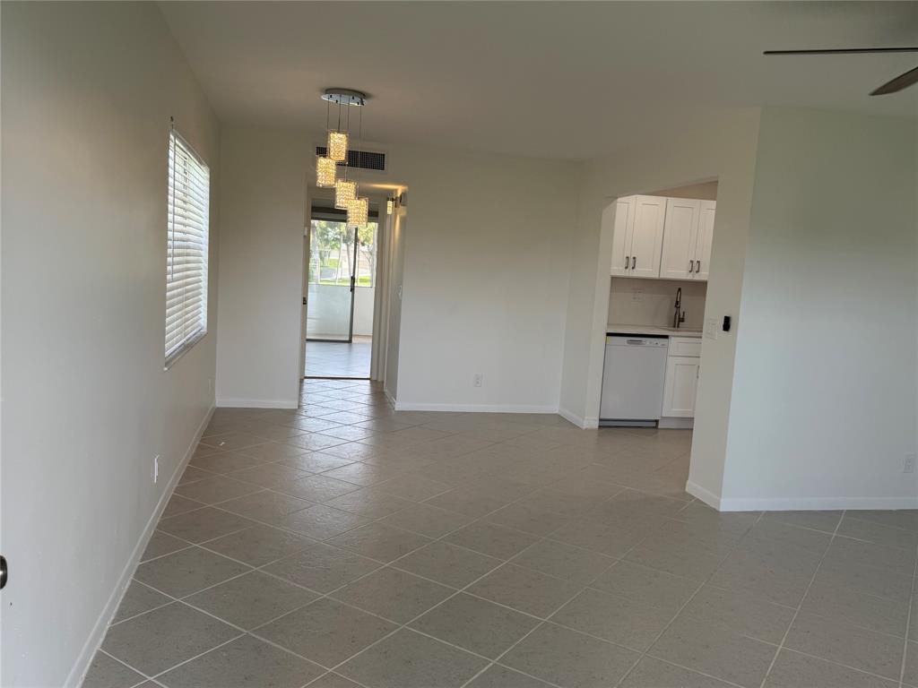 768 P Normandy, Unit 768 Delray Beach, FL 33484 - Photo 2 of 34 a view of a kitchen with wooden floor and a window