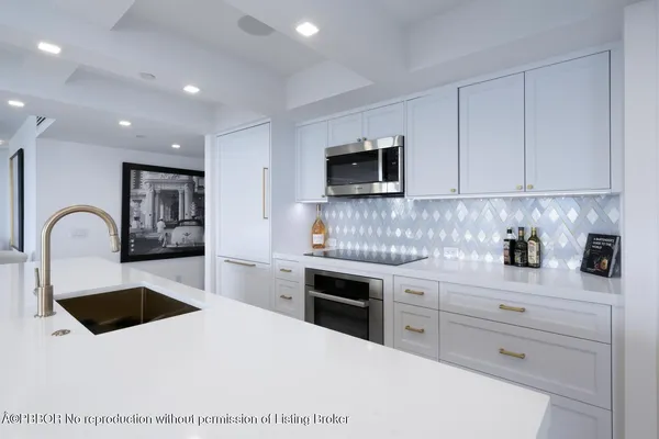 a kitchen with white cabinets stainless steel appliances and sink