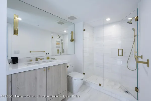 a bathroom with a granite countertop sink a toilet and shower