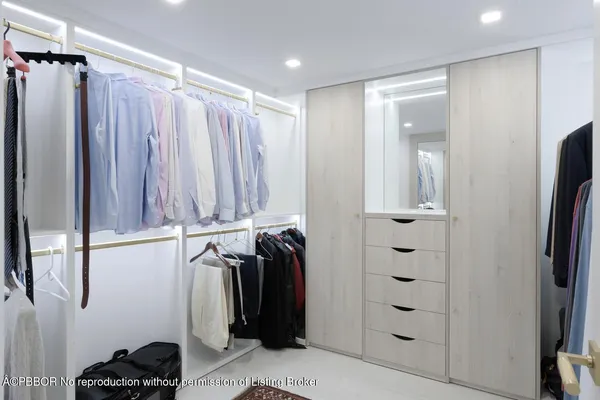 a view of walk in closet with clothes and shoes