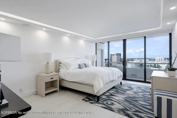a spacious bedroom with a bed and large windows