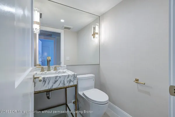 a bathroom with a granite countertop toilet a sink and a mirror