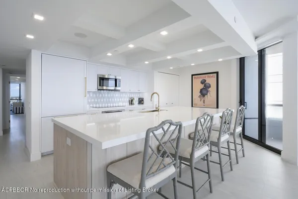 a kitchen with a dining table chairs and refrigerator