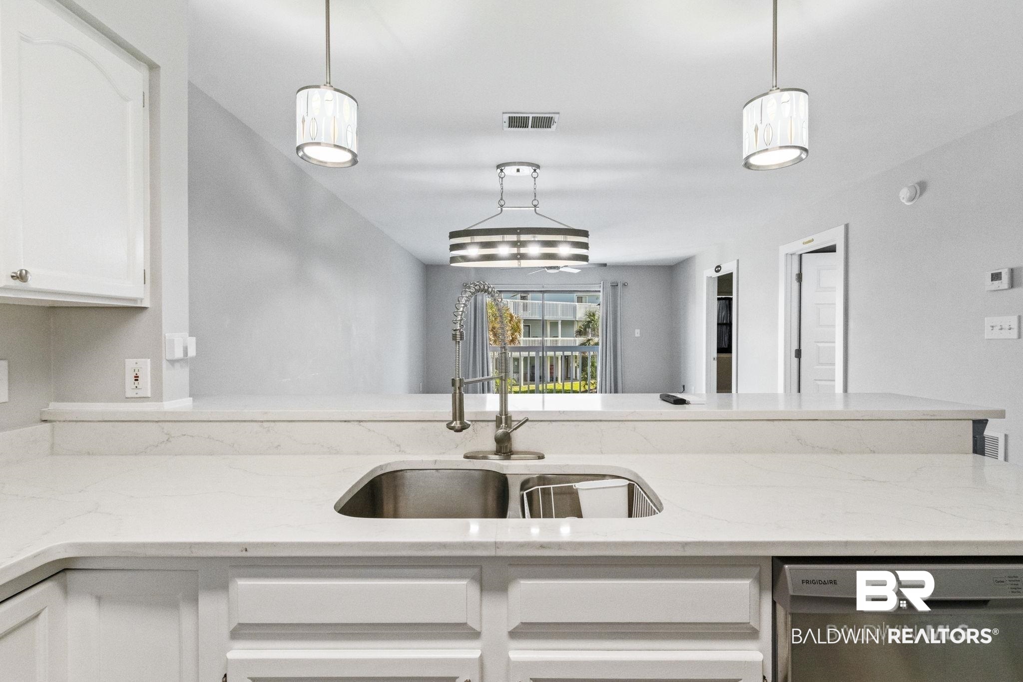 25861 Canal Road, Unit 77 Orange Beach, AL 36561 - Photo 22 of 48 Kitchen with light stone countertops, white cabinets, stainless steel dishwasher, pendant lighting, and a peninsula