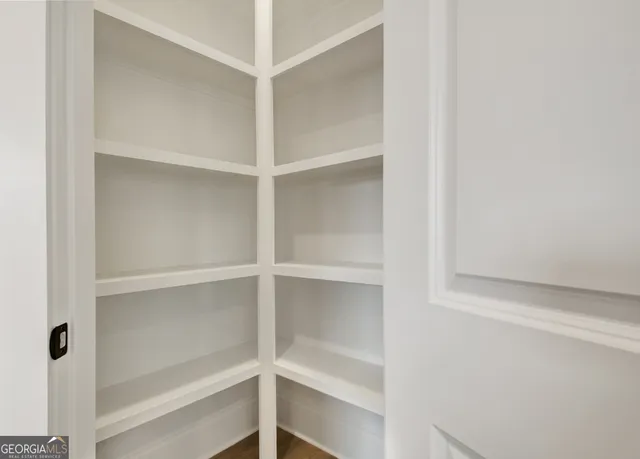 a view of walk in closet with empty racks