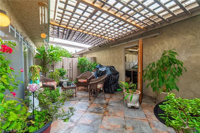 a house with lots of potted plants and a bench