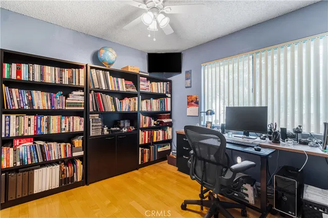 a view of a workspace with furniture and a bookshelf