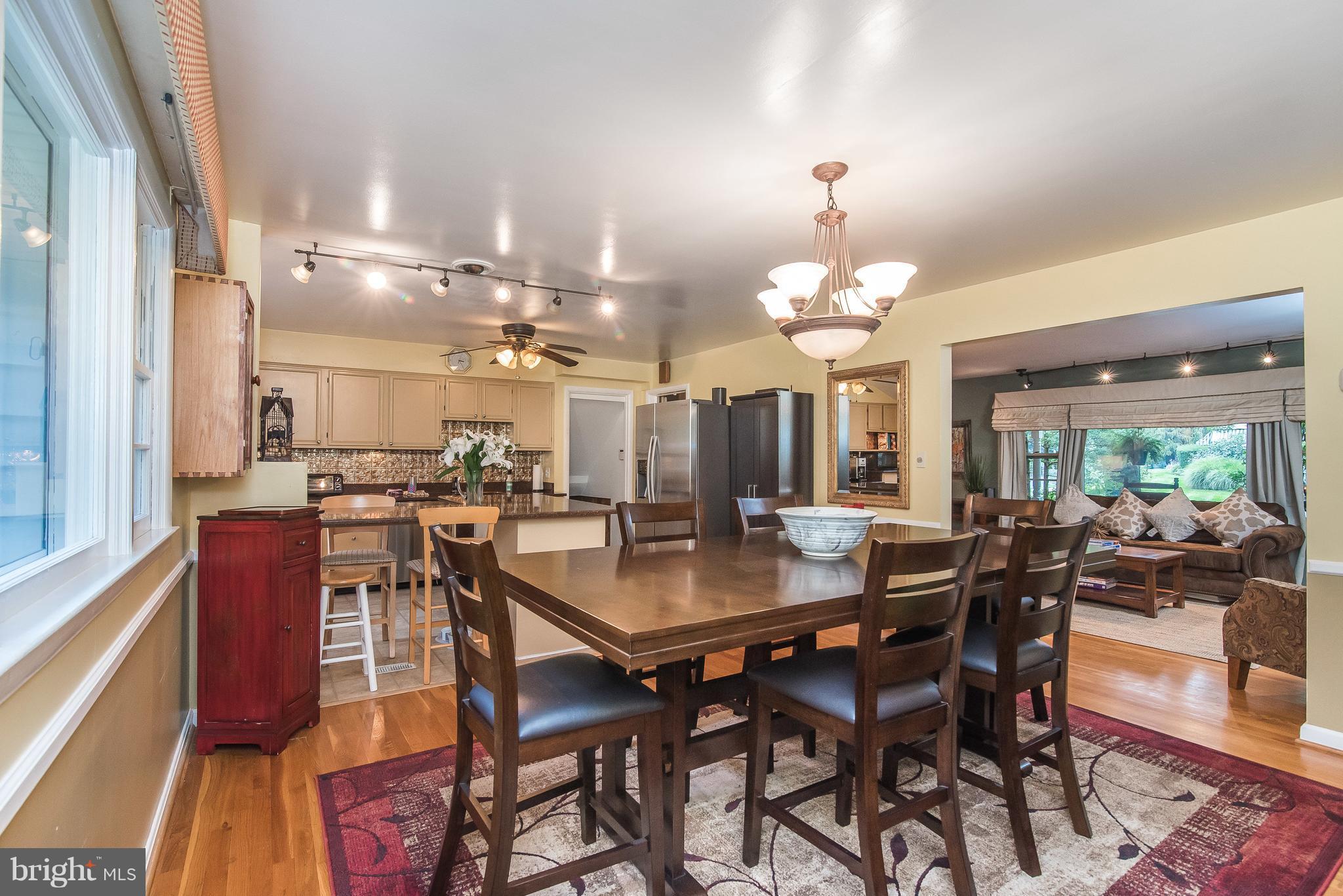 6116 Haddon Hall Road Baltimore, MD 21212 - Photo 39 of 44 a dining room with wooden floor a chandelier a wooden table and chairs
