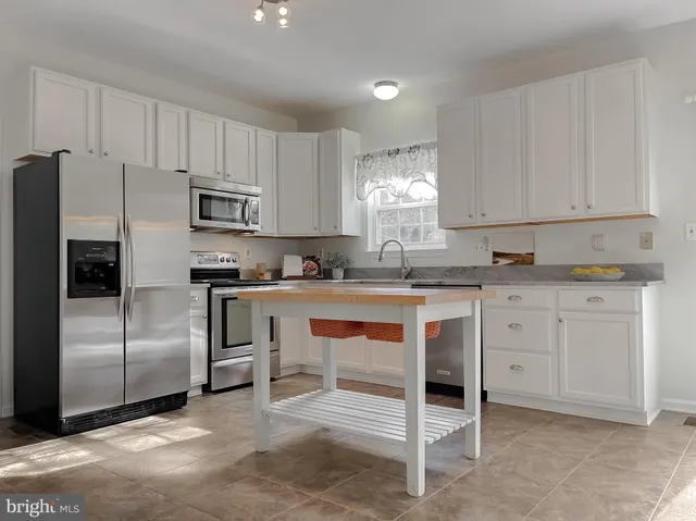 an empty room with wooden floor and chandelier fan