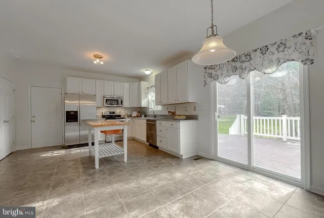 a living room with furniture a bookshelf and a window