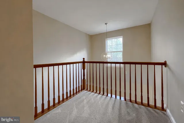 a view of an empty room and chandelier fan