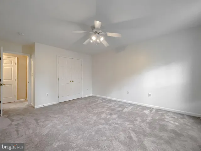 a spacious bedroom with a bed and wooden floor