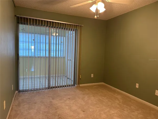 a view of a room with a mirror and a ceiling fan