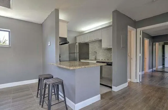 a kitchen with stainless steel appliances granite countertop a sink and a refrigerator