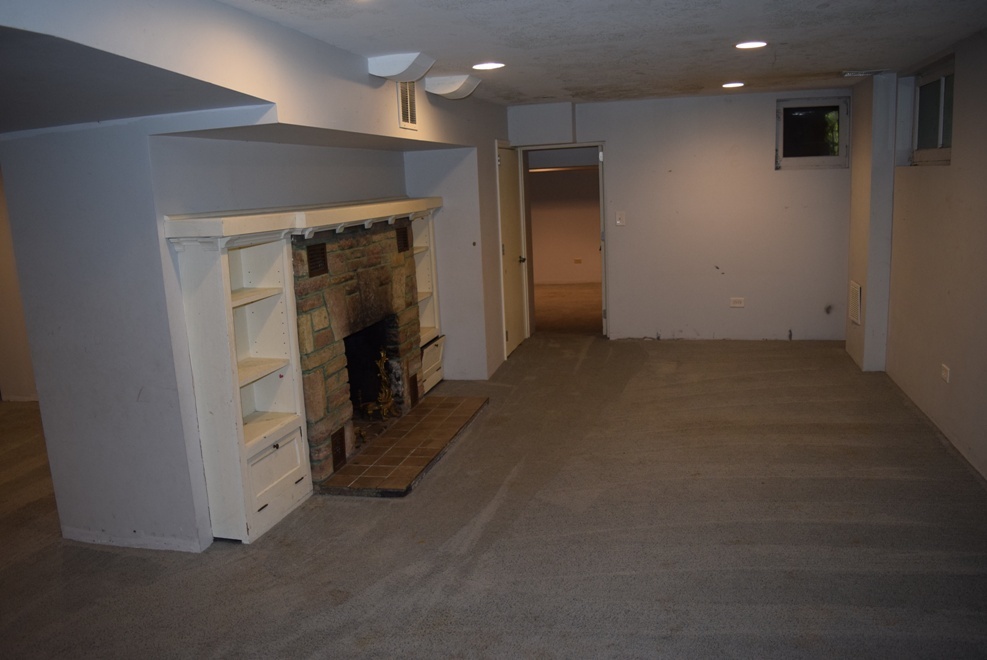 341 Scottswood Road Riverside, IL 60546 - Photo 38 of 46 an empty room with kitchen view and a fireplace
