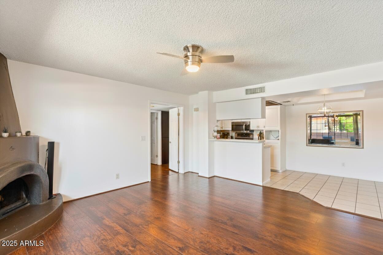 10410 North Cave Creek Road, Unit 2229 Phoenix, AZ 85020 - Photo 5 of 27 a view of a kitchen and an empty room with wooden floor
