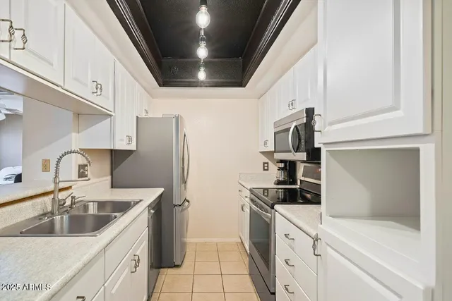 a kitchen with stainless steel appliances granite countertop a sink and a refrigerator