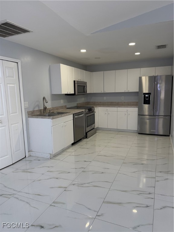 4427 25th Street Southwest Lehigh Acres, FL 33973 - Photo 4 of 20 a large kitchen with stainless steel appliances granite countertop a sink and cabinets