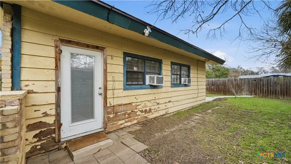 a view of a house with a large window and wooden fence