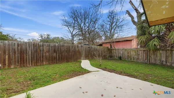 a view of a backyard with wooden fence
