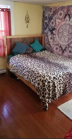 a picture of a bedroom with wooden floor