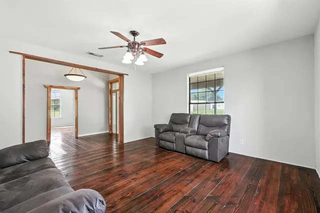 a living room with furniture and a wooden floor