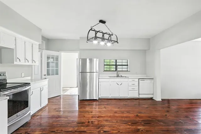 a kitchen with stainless steel appliances a white cabinet and a stove top oven