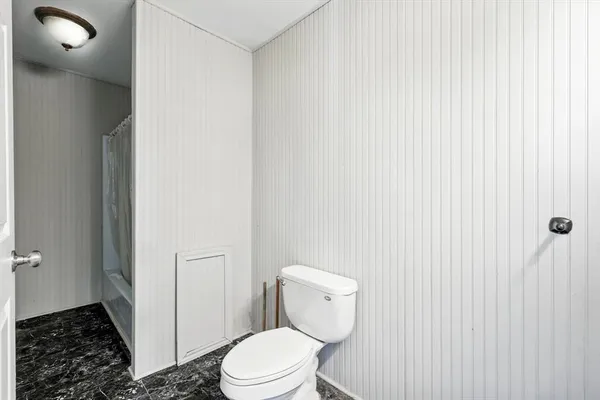 a white toilet sitting next to a shower