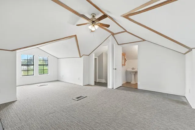 a view of a big room with wooden floor and windows