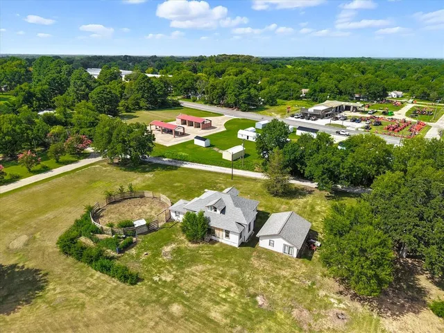 an aerial view of a house with a garden and lake view