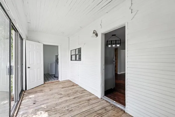 a view of a hallway with wooden floor and closet