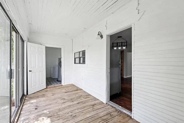 a view of a hallway with wooden floor and closet